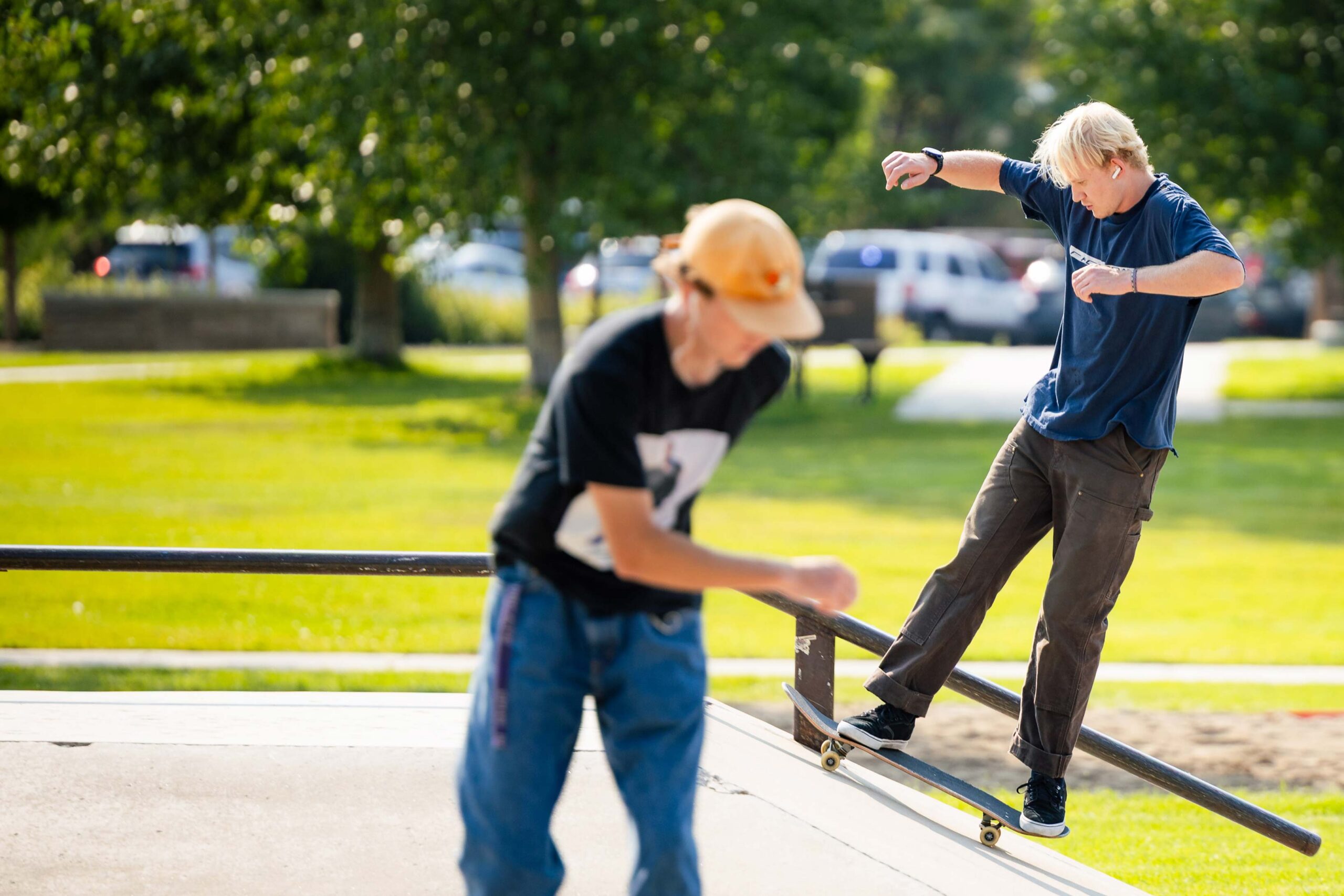Two students skate through the campus skate park.