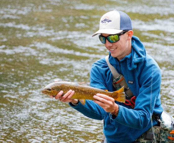 A student displays the beautiful trout he caught during a biology lab.