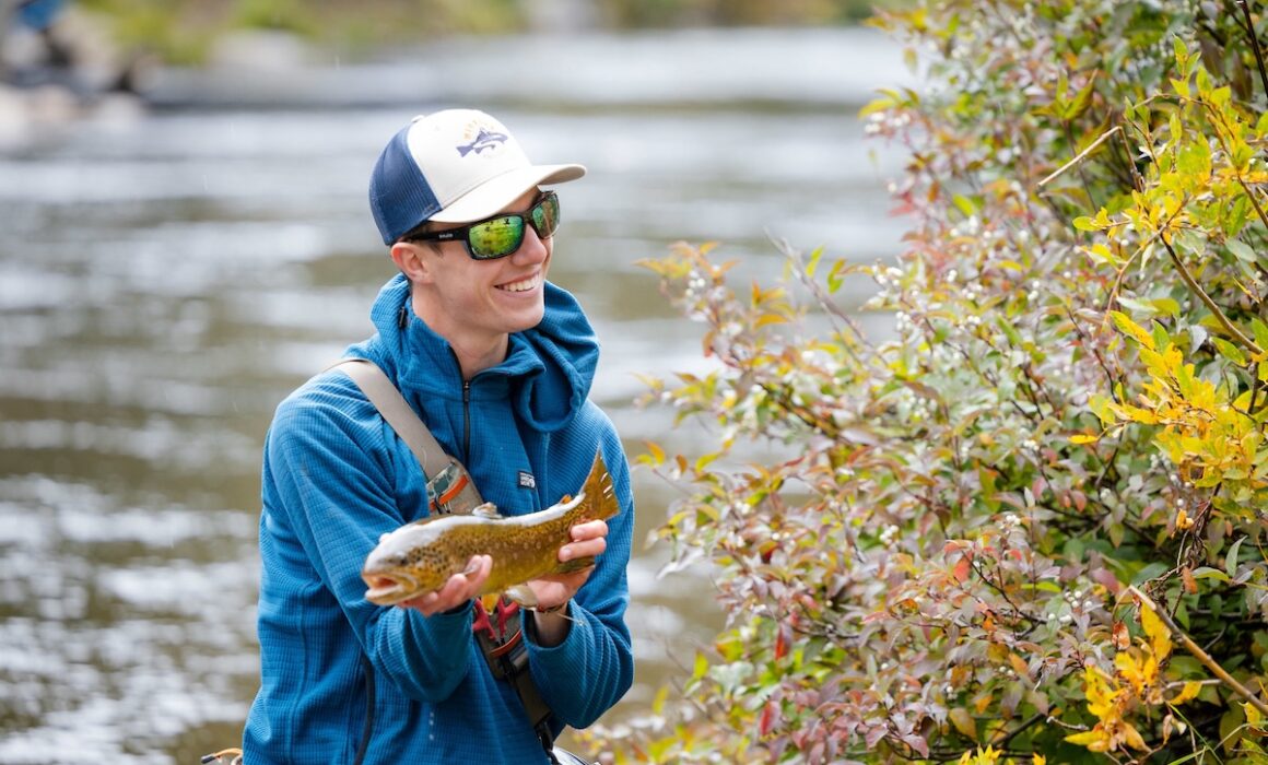 A student displays the beautiful trout he caught during a biology lab.