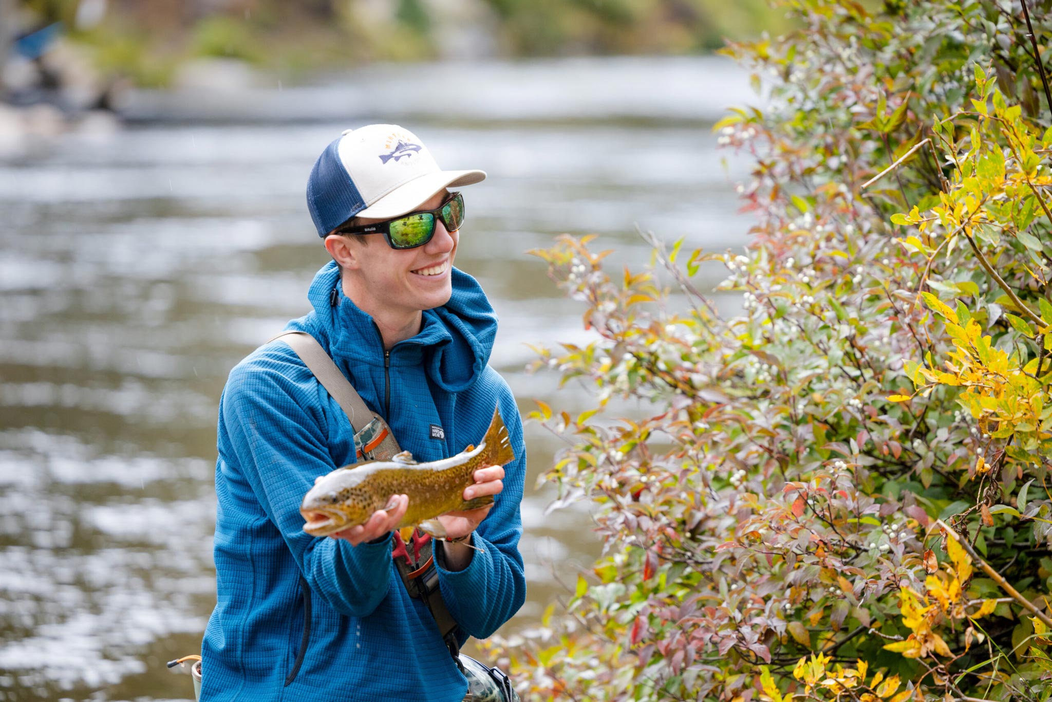 A student displays the beautiful trout he caught during a biology lab.