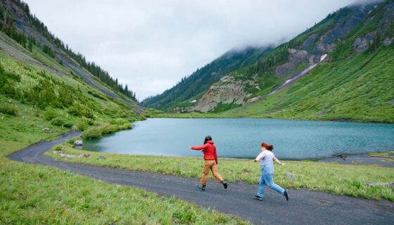 Two girls frolic on the road next to Emerald Lake.