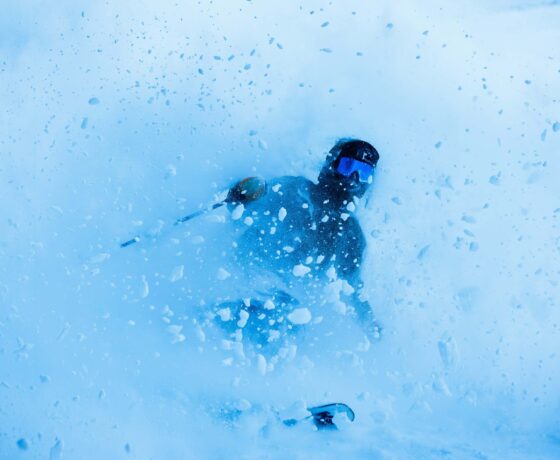 A skier skis out of a powder slash.