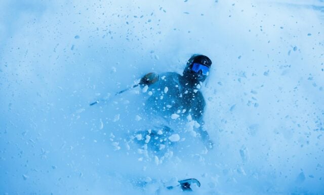 A skier skis out of a powder slash.
