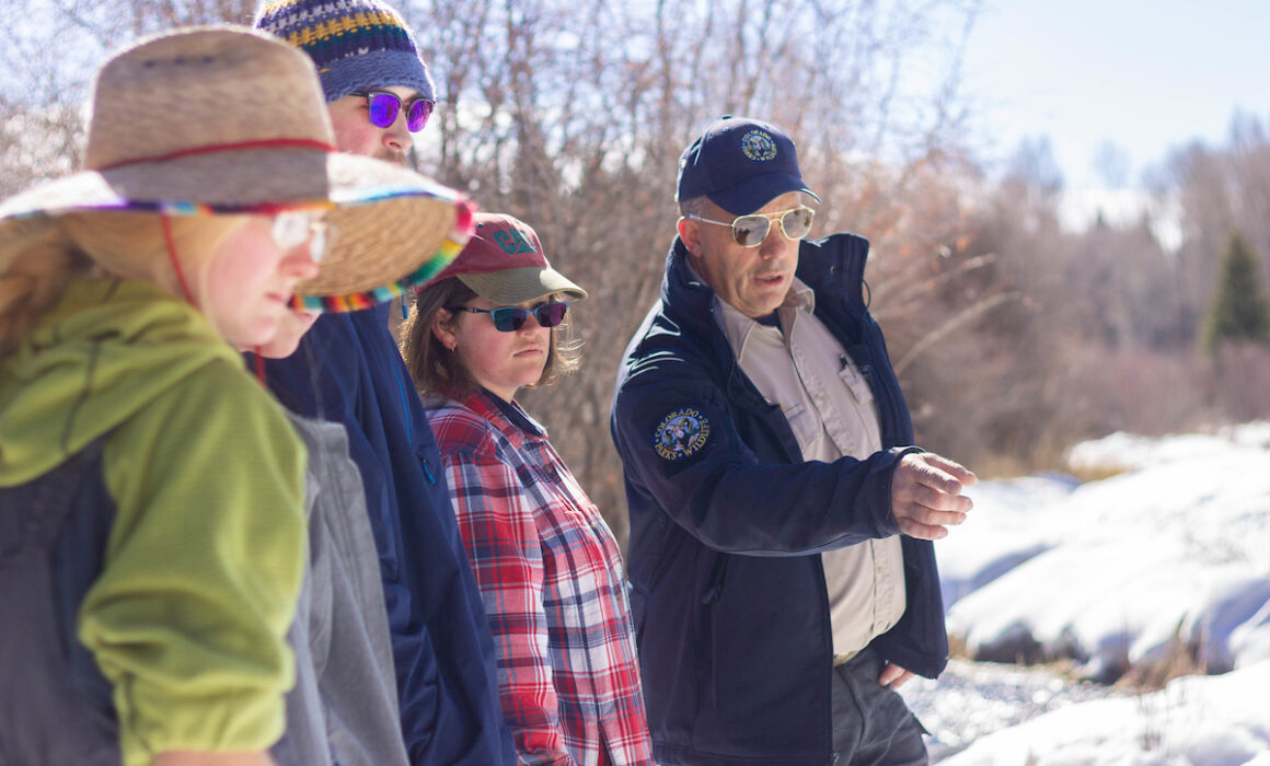 CPW employee Dan Zadra points out tracks to Wildlife Society club members.