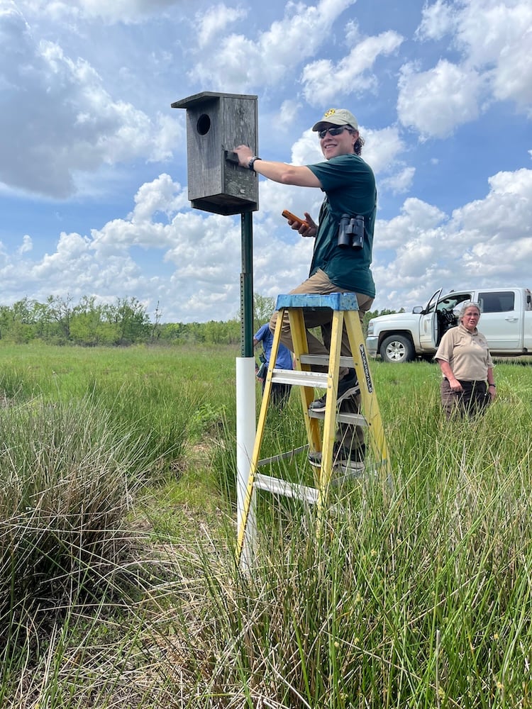 A Western graduate student performs a field test along the Mississippi River banks.