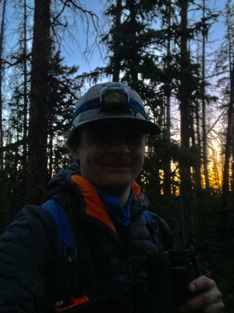 Arrow Meyers takes a selfie of himself in a forest with a helmet on.