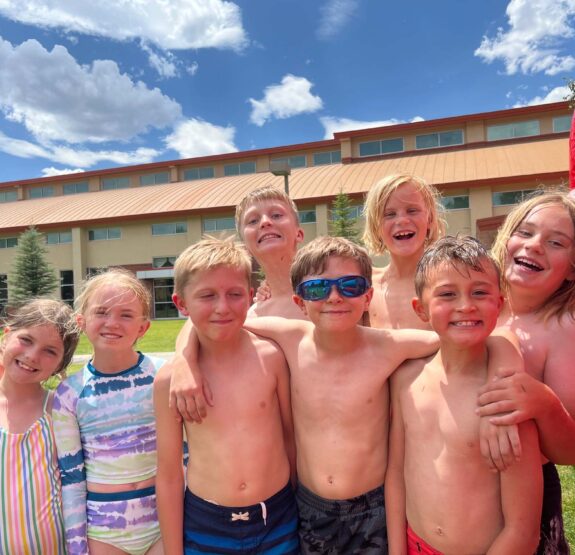 Group photo of kids in swimsuits at a Junior Mountaineers summer camp.