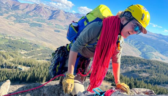Male western student smiles as he reaches the top of the summit