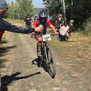 Western Mountain Bike teammate collects water at a race.