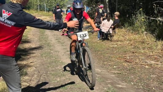 Western Mountain Bike teammate collects water at a race.