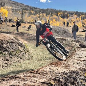 A Western Athlete competes in the Dual Slalom at Nationals with a blue sky and golden aspens in the background.