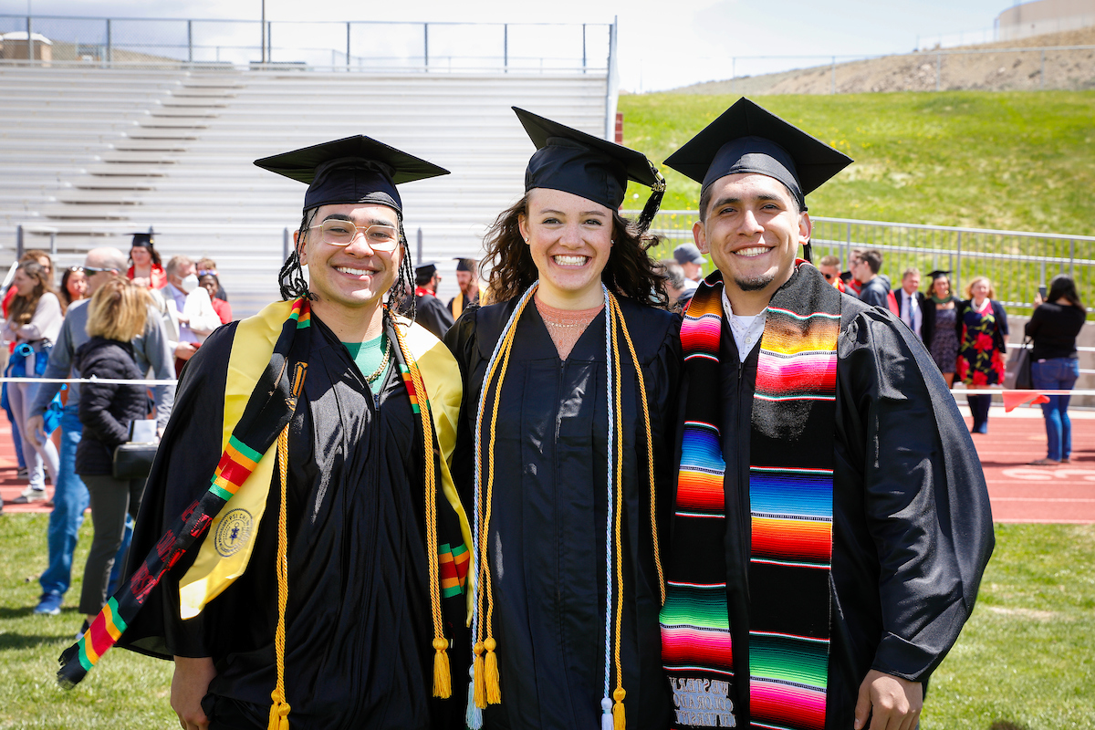 Three graduates pose for a photo after the 2021 commencement ceremony.