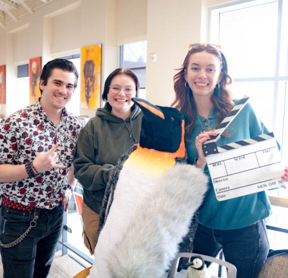 The KWSB team poses next to a stuffed penguin during the club fair.
