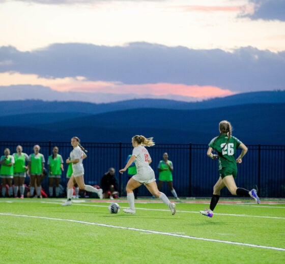 Soccer plays chase a ball at the Katy O. Rady Field during sunset.