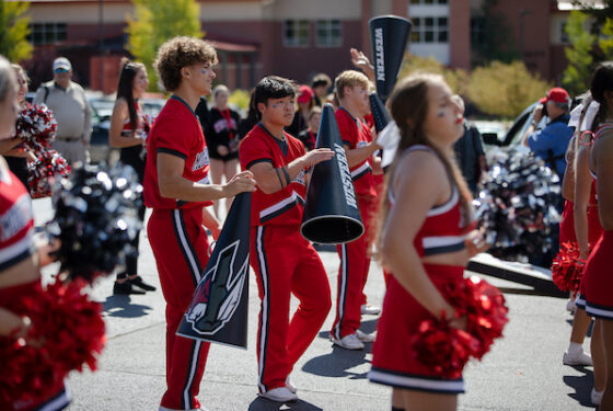 A photo of a couple of the male cheerleaders during a performance at the Homecoming Tailgate.
