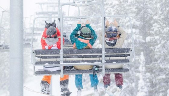 Western Students holding up Ws on a chair lift at Crested Butte mountain.