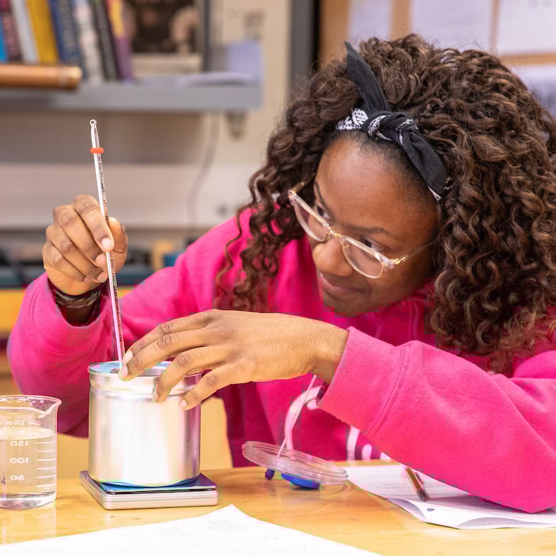 A student reads a temperature recording on a thermometer.