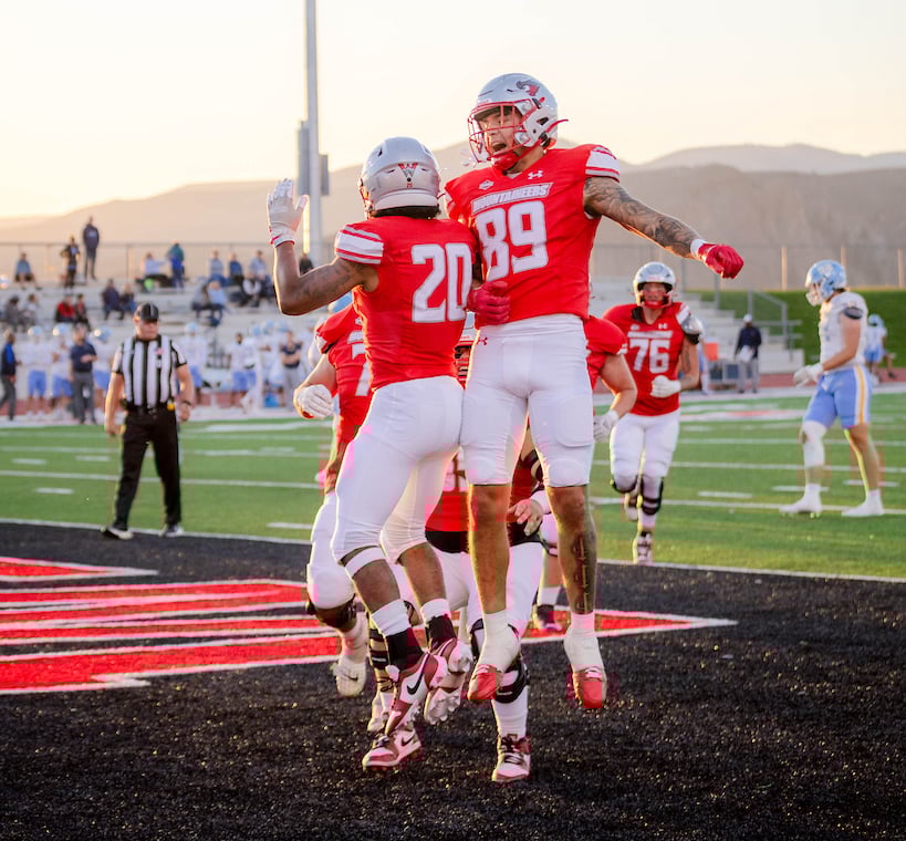 football players jumping in the air celebrating during the family weekend football game againts fort lewis college