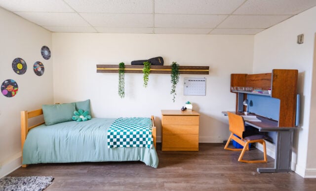 A side of a Ute Hall dorm room featuring a bed, dresser, and desk.