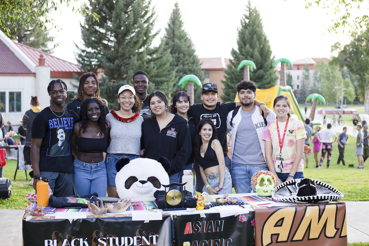 A group of students pose for a photo together at the Multicultural Center club table at A Taste of Western.