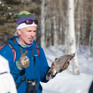 Dr. Pat Magee holds a taxidermied bird and gives a lecture while on a field trip with his ornithology class at Mill Creek.