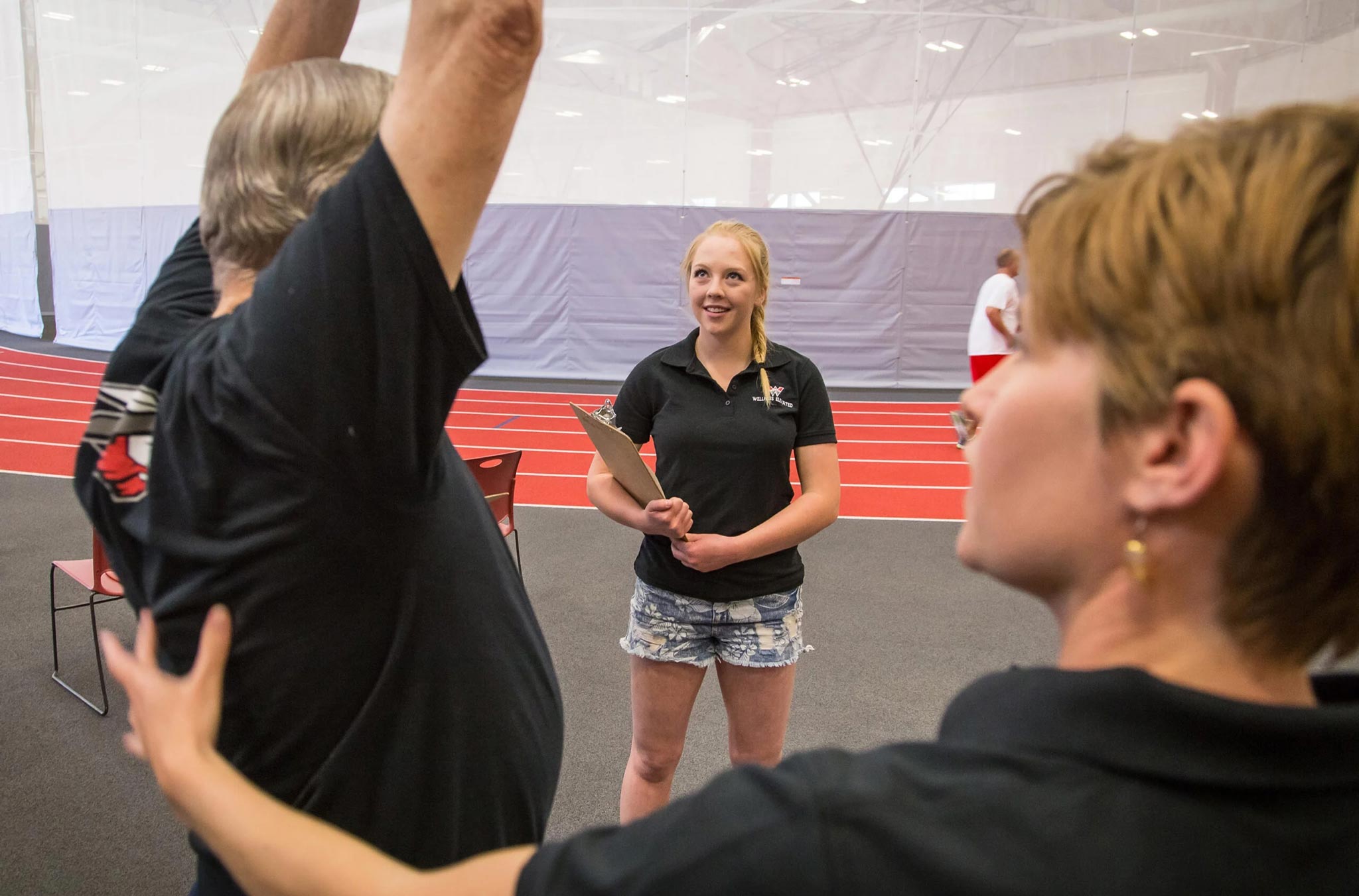 A student observes a person exercising in the Mountaineer Field House.