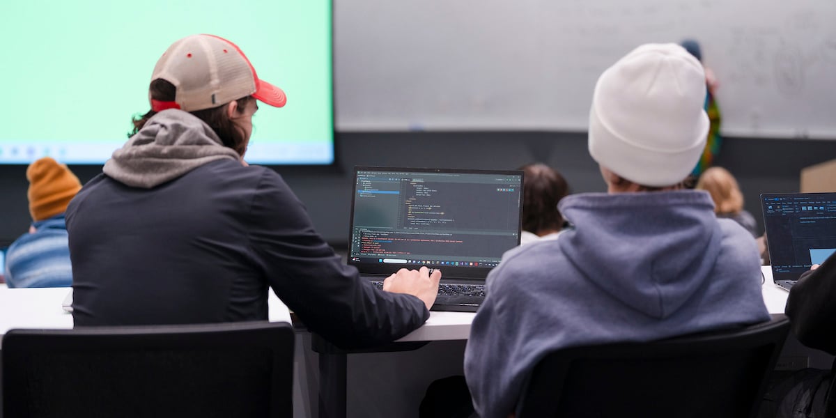 A student works on some code on his laptop during a computer science class.