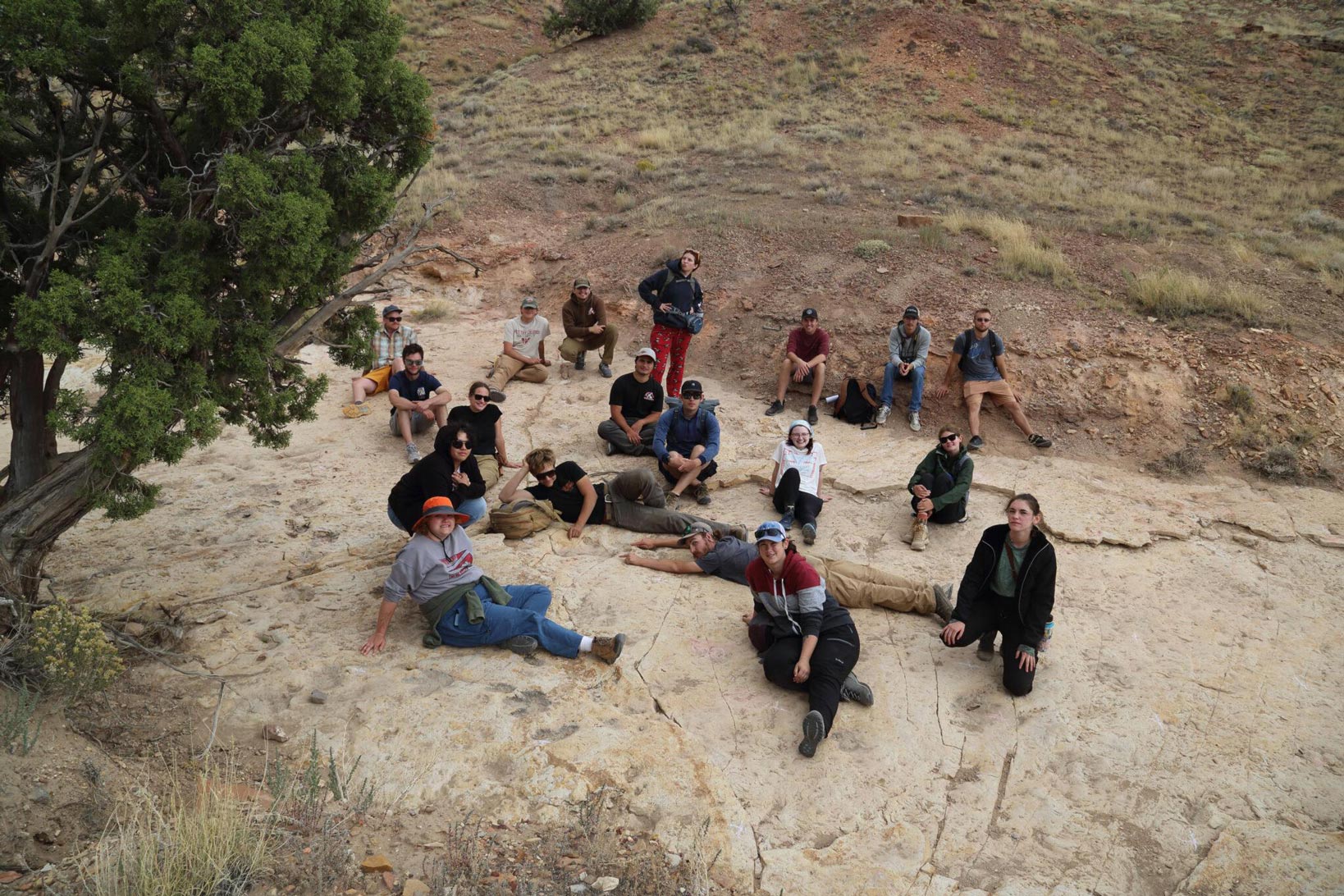 A group of students pose for a picture near the dinosaur track site