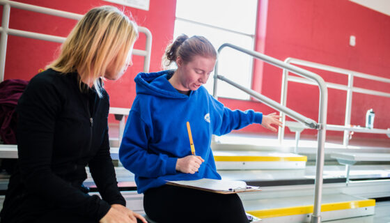 A student makes an exercise plan on the stadium bleachers.