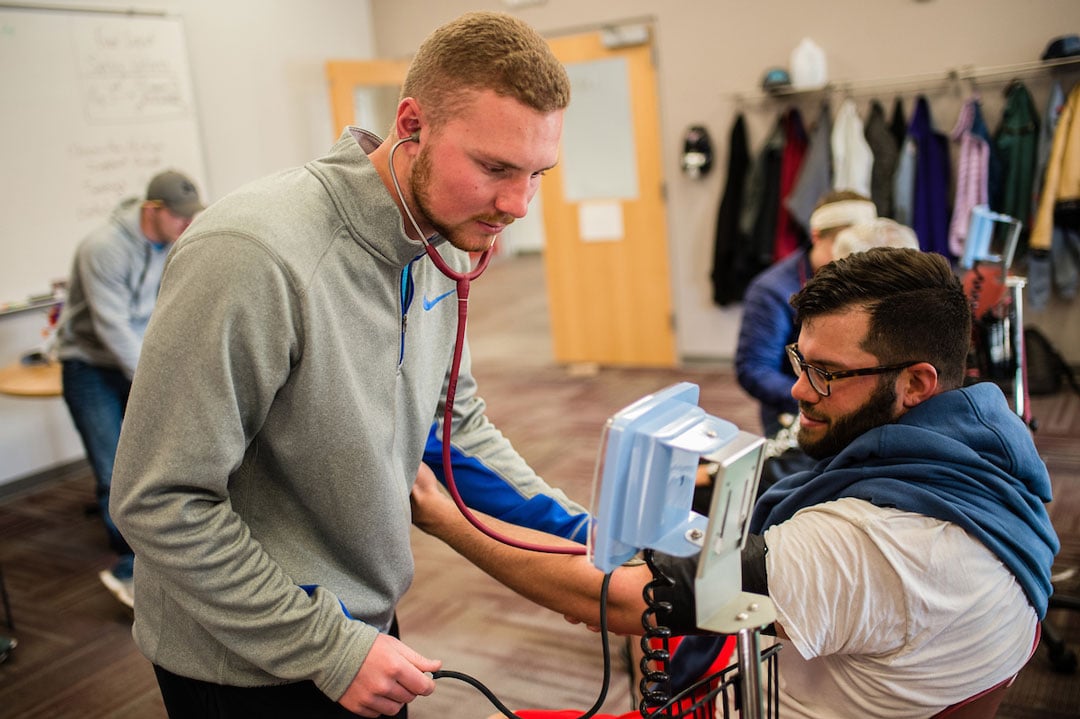 Student helps older community member learn more about their health.