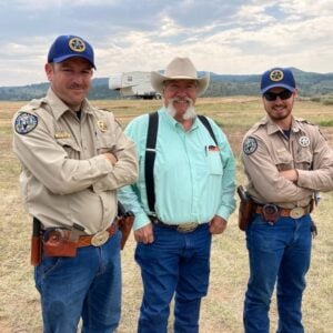 Ross McGee poses with a coworker and a local rancher.