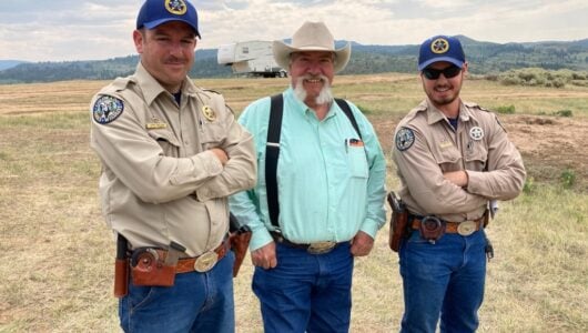 Ross McGee poses with a coworker and a local rancher.