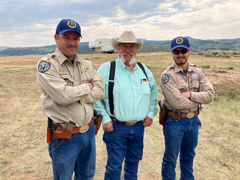 Ross McGee poses with a coworker and a local rancher.