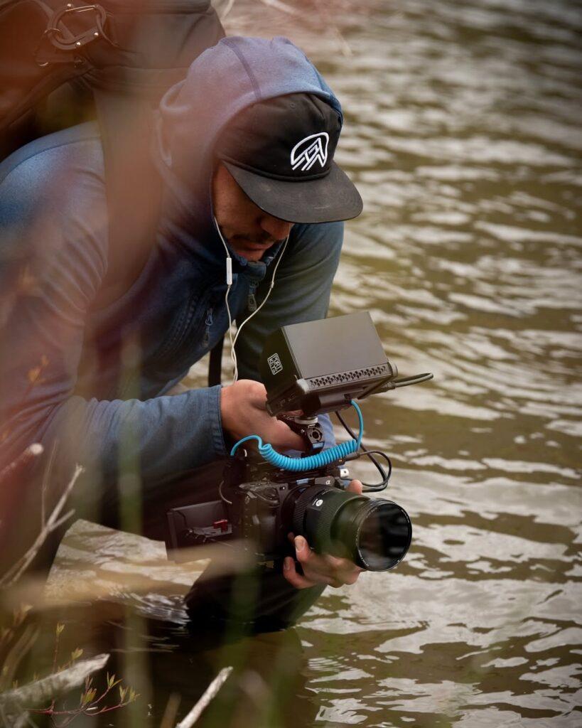 Sage in the river shooting for his marketing company