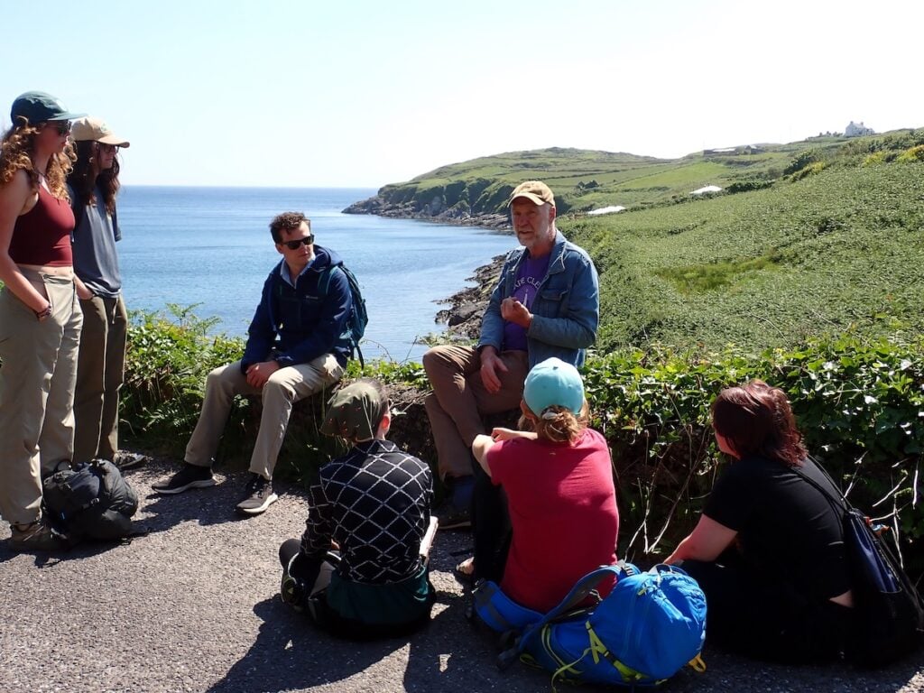 Students gather around for storytelling by the sea in Ireland.