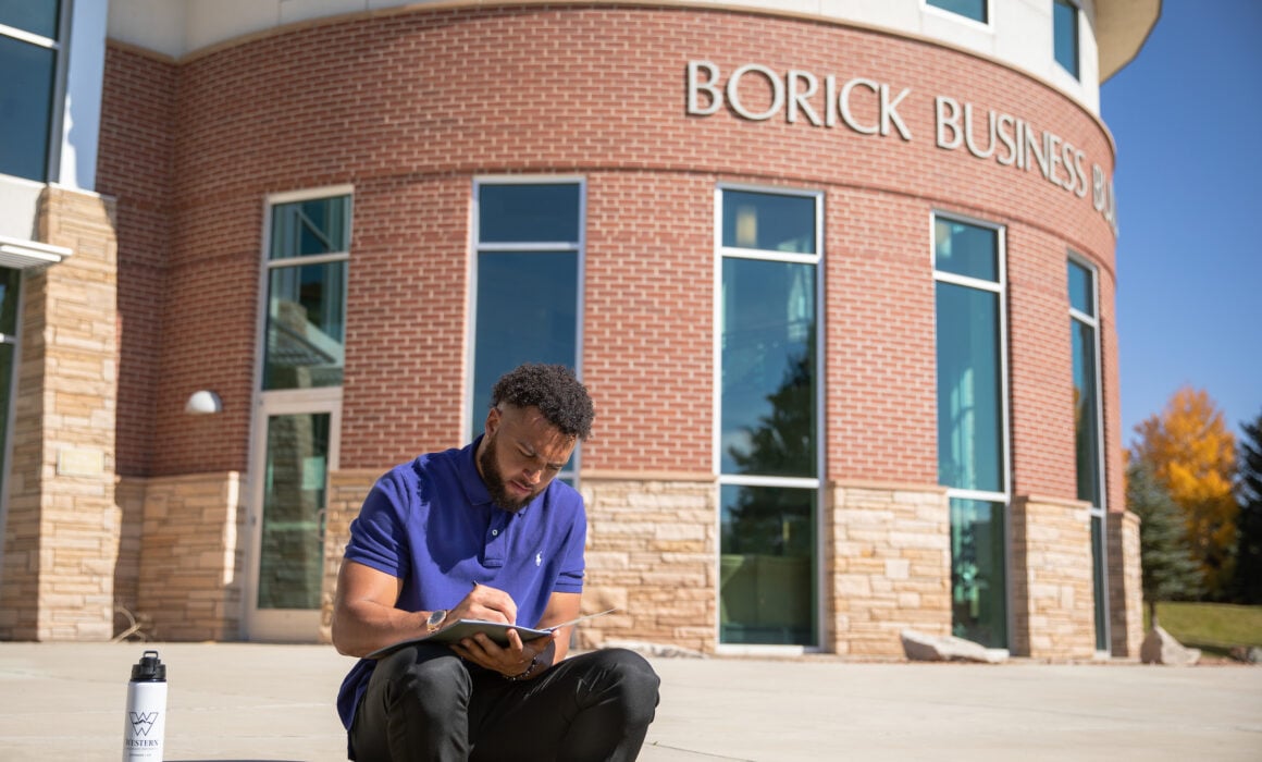 A student reads outside the Borick Business Building.