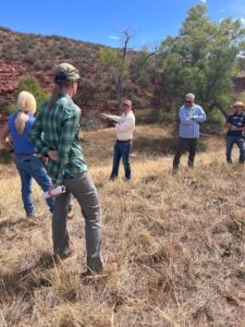 A group of people stand in a circle during a watershed tour.
