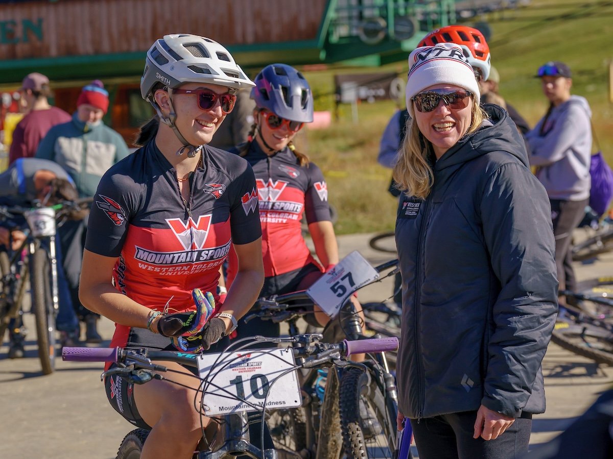 vA Western cycling athlete sits on her bike and talks with a coach before the women's short track cross country race at Crested Butte Mountain Resort.