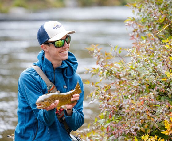 Student displays a trout he caught during a biology lab