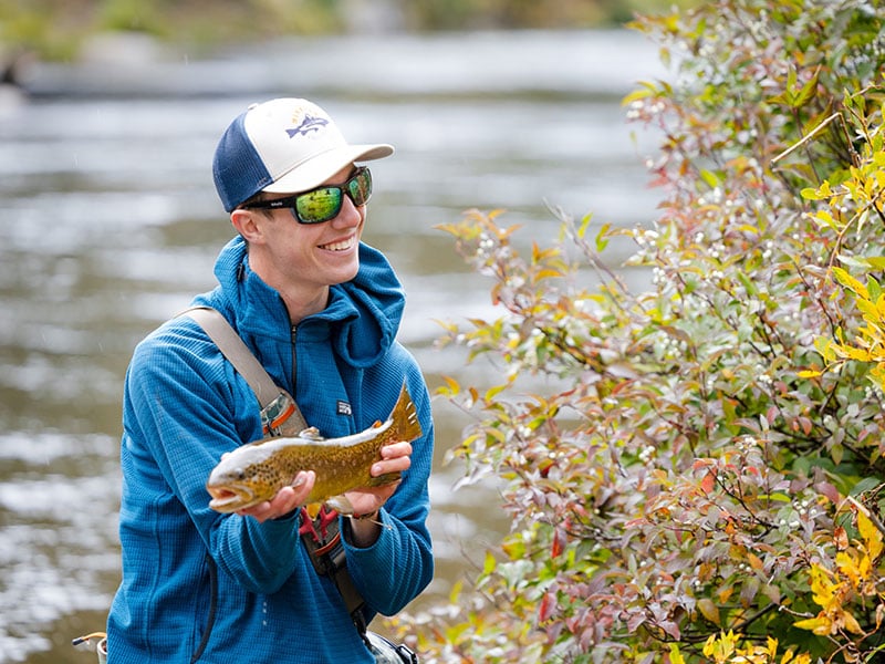 Student displays a trout he caught during a biology lab