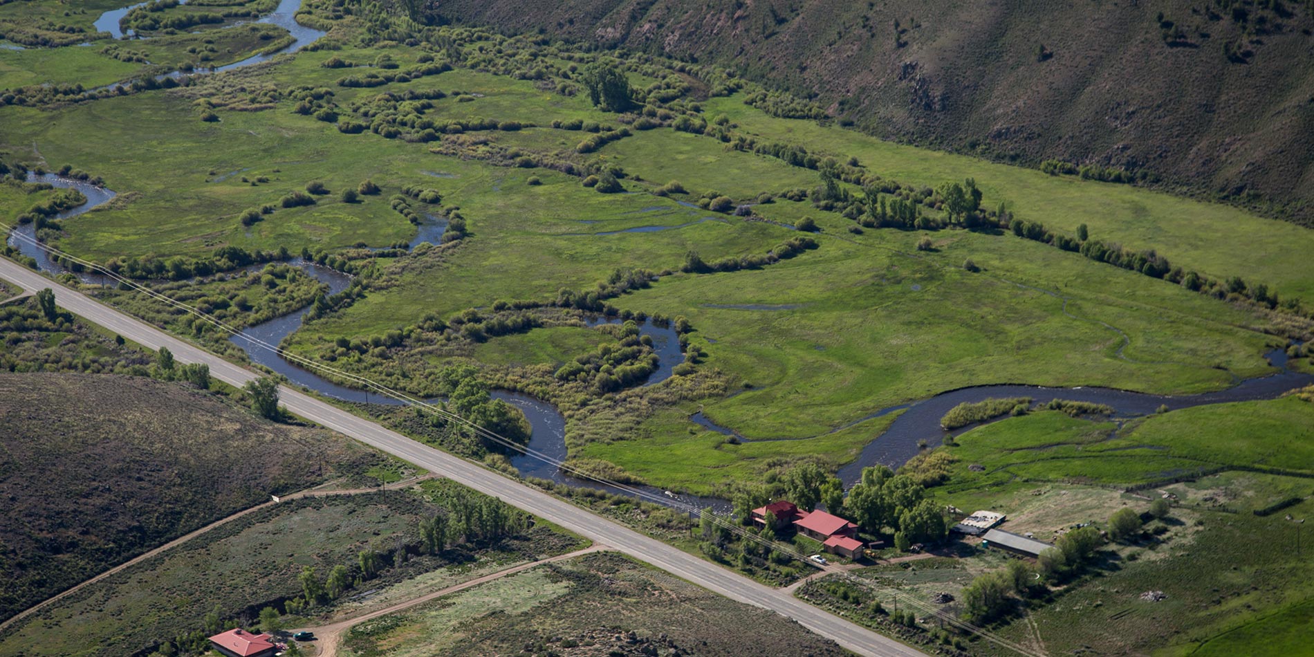 Scenic aerial picture of Coldharbour Sustainable Living Center and a flooding Tomichi Creek