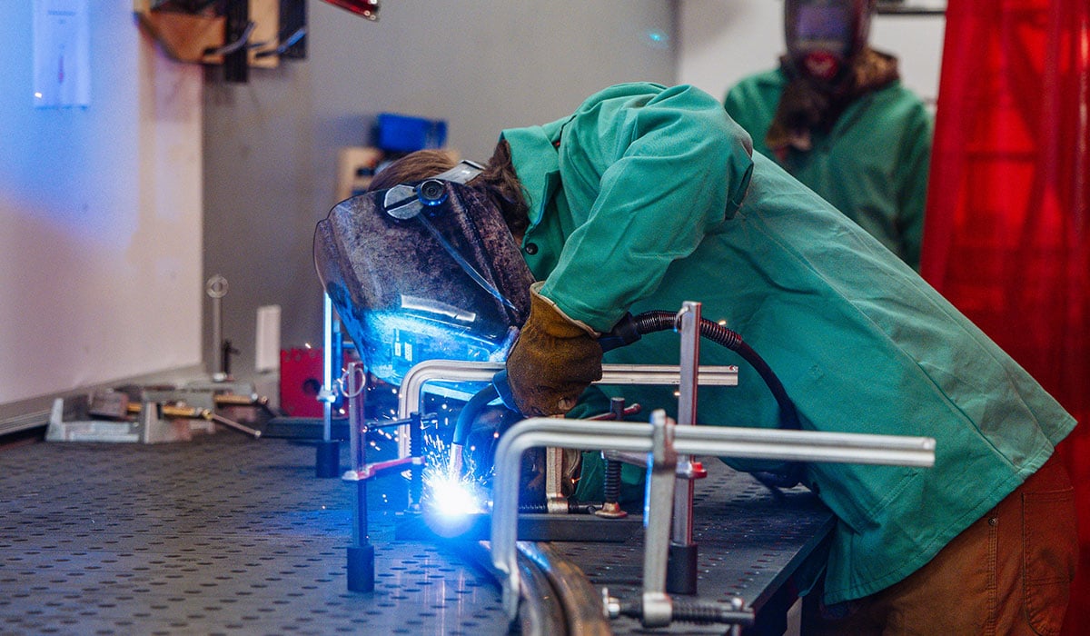 Mechanical Engineering students weld a rail for Rail Jam in Makerspace