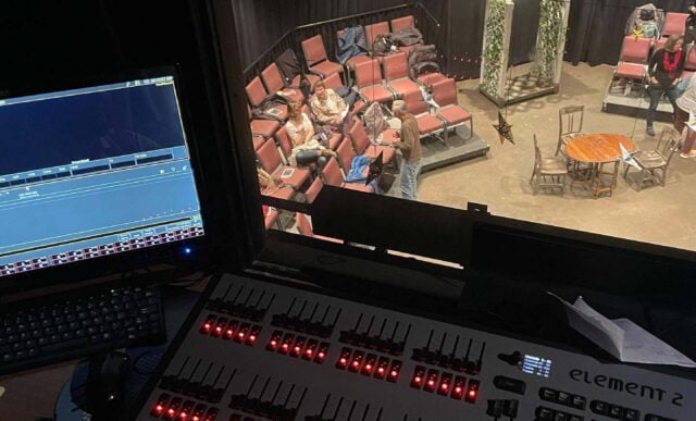 A screen and panel above a stage.