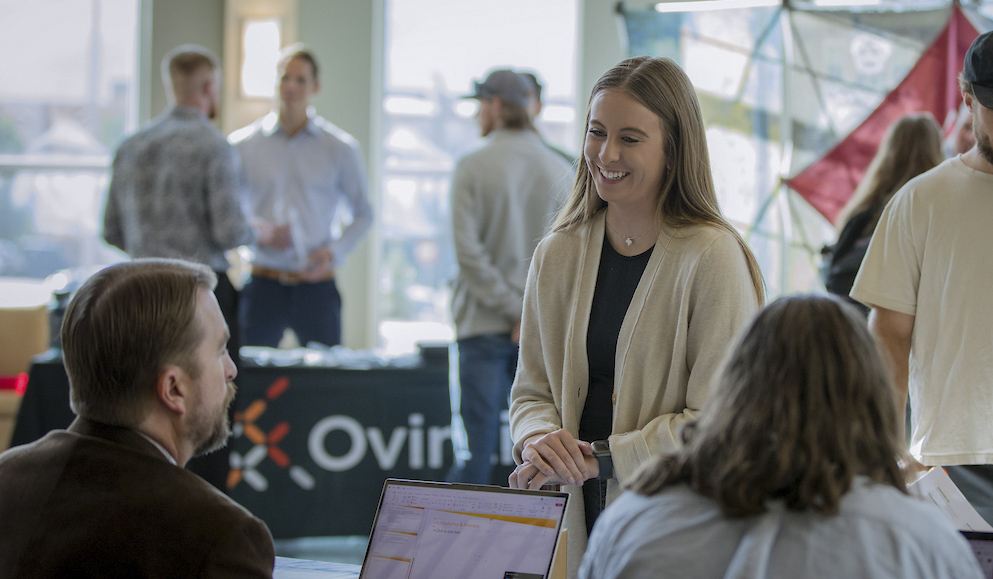 A student speaks to an employer at an energy management career fair.