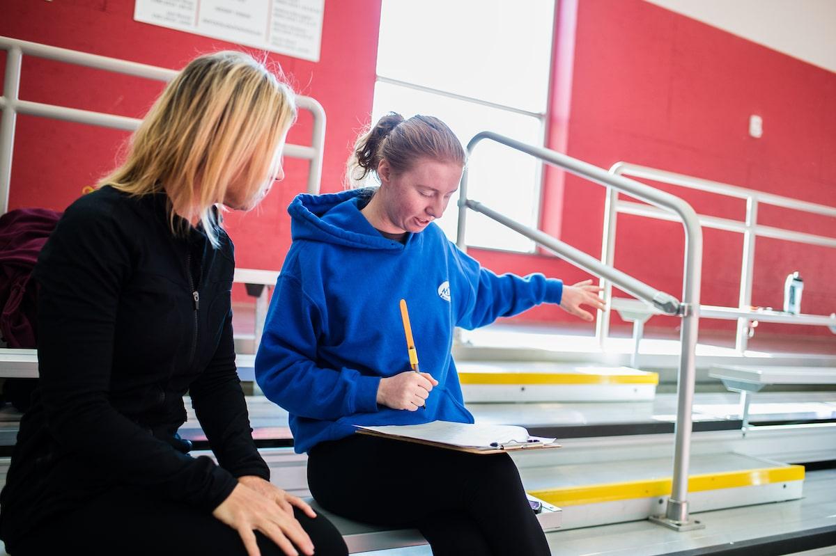 Student works on exercise assessment for client in the gym.