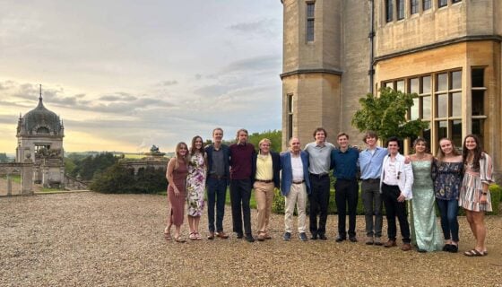 Group photo of a Harlaxton class at the manor during sunset.