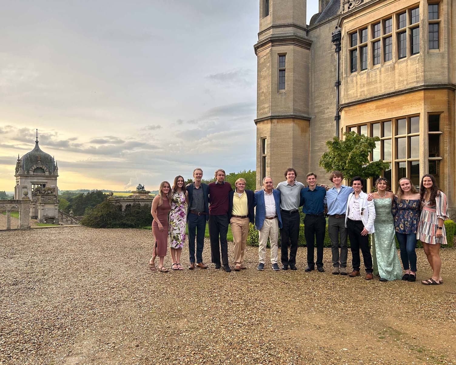 Group photo of a Harlaxton class at the manor during sunset.