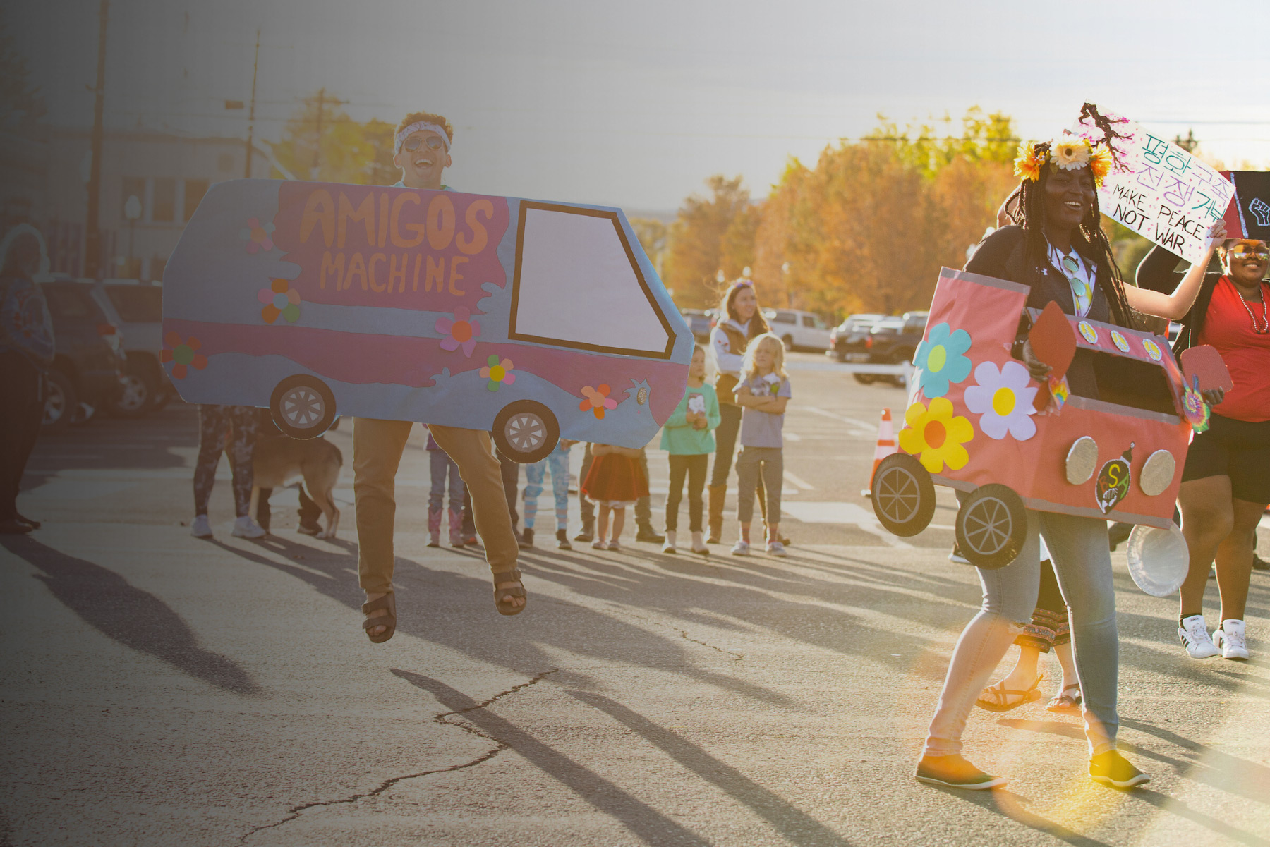 Students carrying 70s themed signs during the Western Colorado University Homecoming Parade