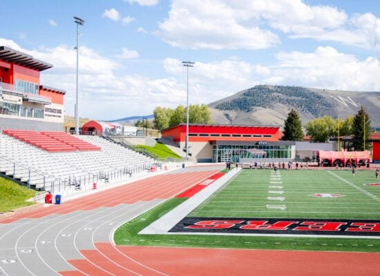 On a hill looking down at the Mountaineer Bowl's field, track, and grandstands with W Mountain in the background.