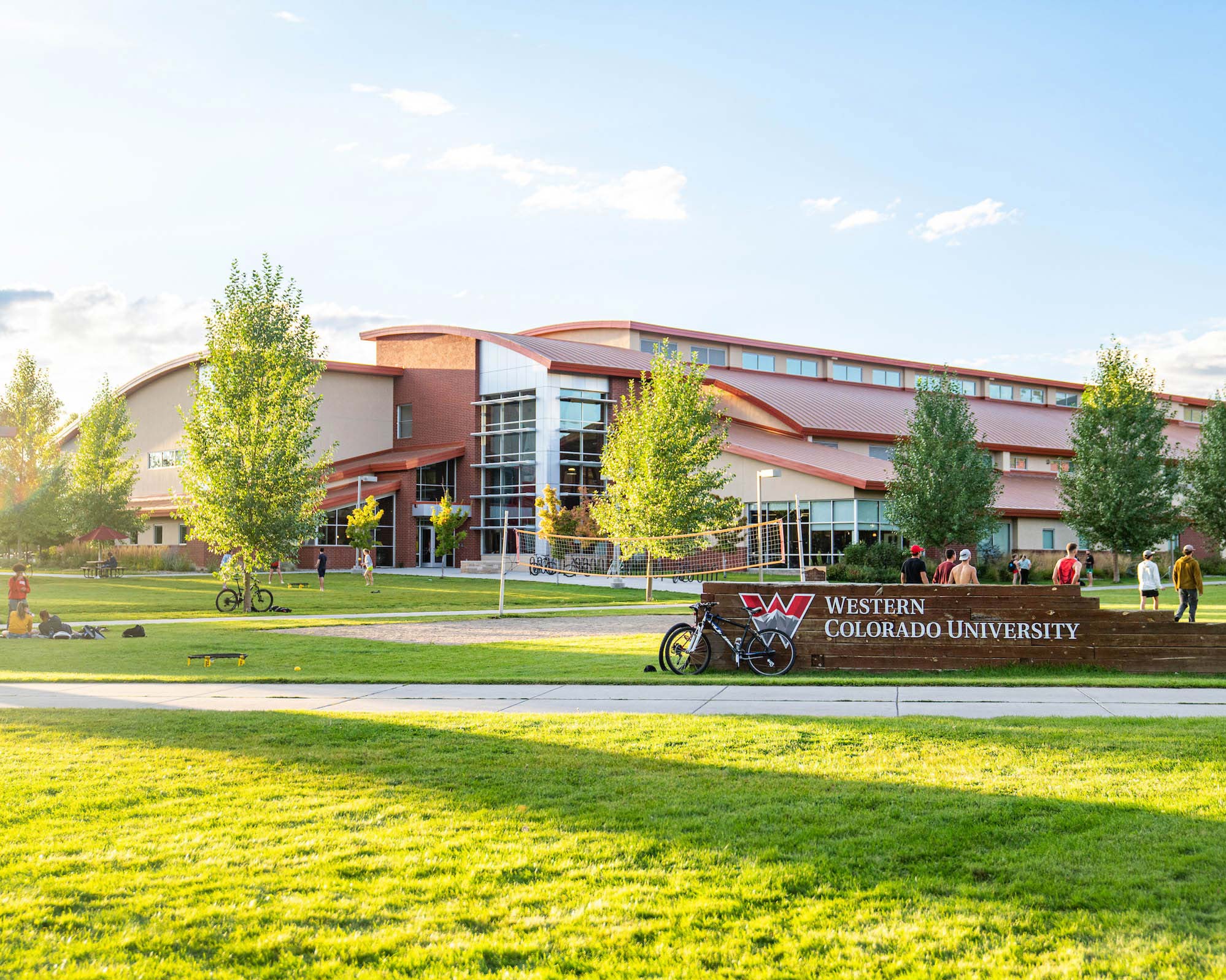The Western Colorado University Field House pictured with several groups of students and a skate park.